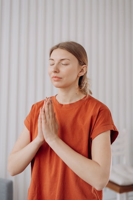Woman performing a peaceful yoga pose in a beautifully lit room.